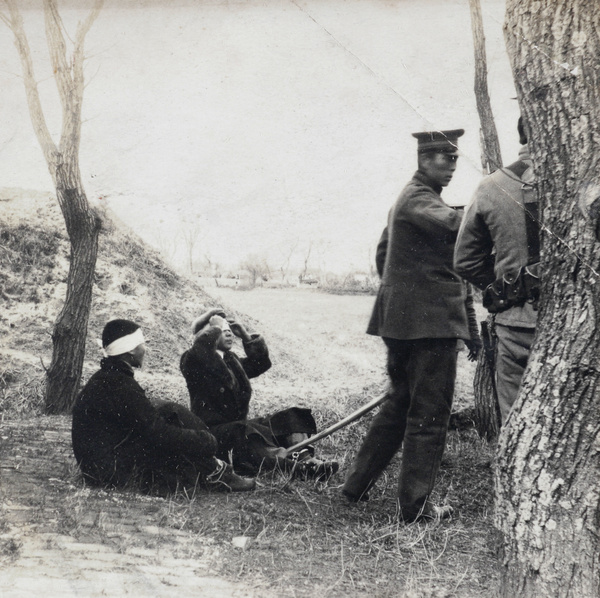 Soldiers with blindfolded prisoners