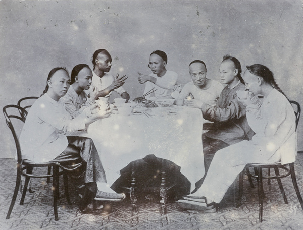 A studio photograph of diners playing a finger number guessing game