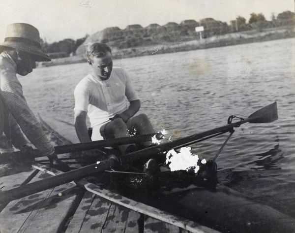 Oarsman in sculler, with a helper