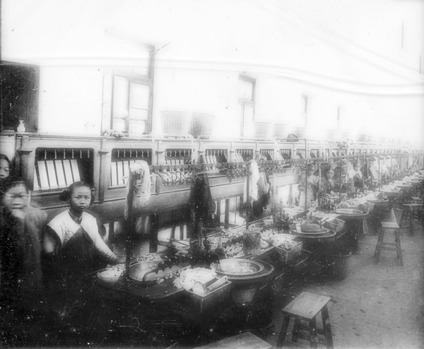 A silk filature (spinning mill), showing workers with reeling machines and silk cocoons being stoved or stifled, Shanghai