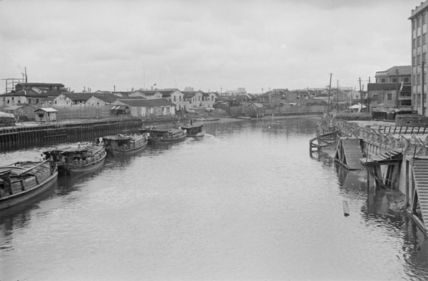 Boat train passing fortified jetty and Sihang warehouse, Soochow Creek, Shanghai