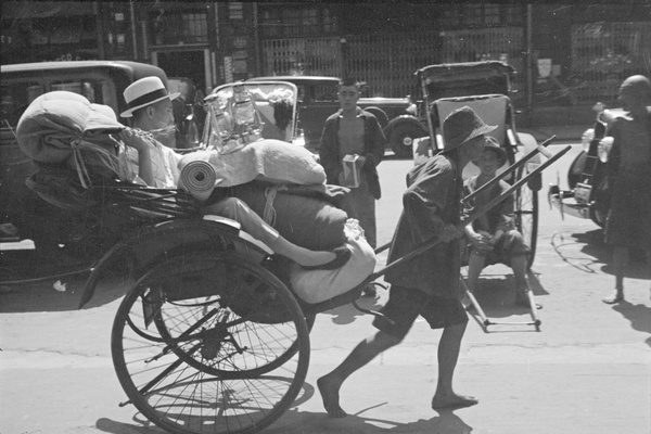 Rickshaw passenger, with hurricane lamps and bedding, Shanghai