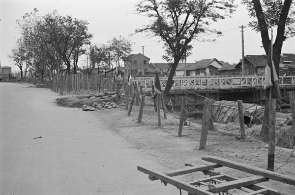 Defences and French flags near creek bridge, Shanghai