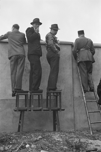 Journalists and a French Concession policeman watching fighting, Shanghai