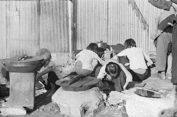 Children tending cooking stoves in street, Shanghai