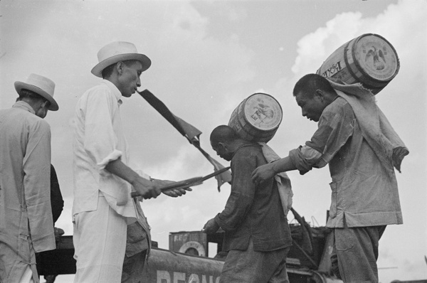 Stevedores loading barrels, with overseer and tally sticks, Shanghai