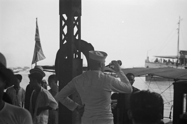 Sailor drinking beer on passenger jetty, Shanghai