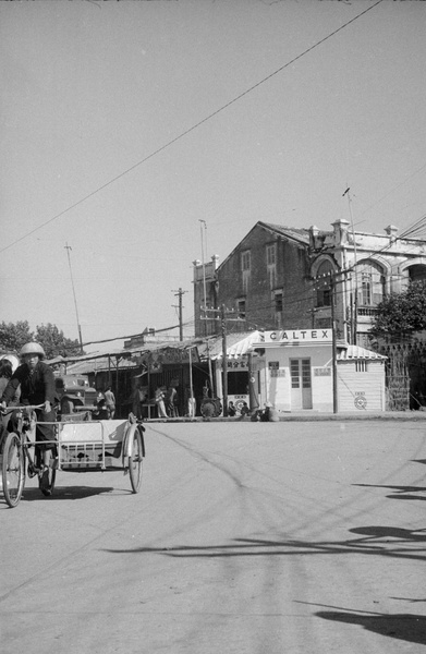 Rickshaw cyclist and Caltex garage