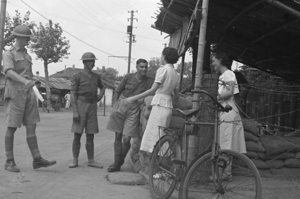 Women and British soldiers chatting at a guard post, Shanghai