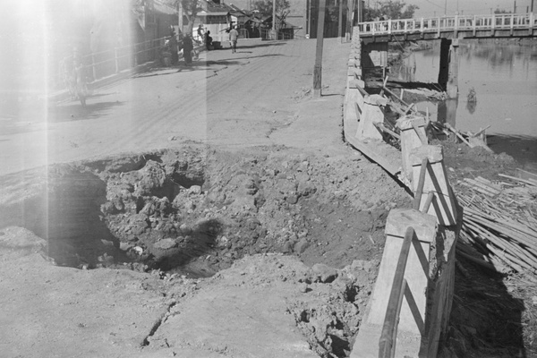 Bomb crater near small bridge, Shanghai