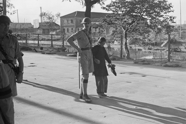 British soldier helping a woman with bound feet, Shanghai