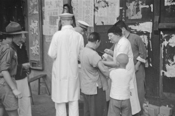 Chinese woman being inoculated in the street, Shanghai