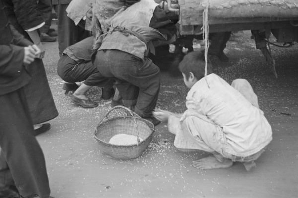 Gathering up rice fallen from a lorry, Shanghai