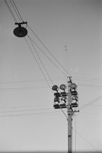 Two airplanes flying high above overhead wires, Shanghai