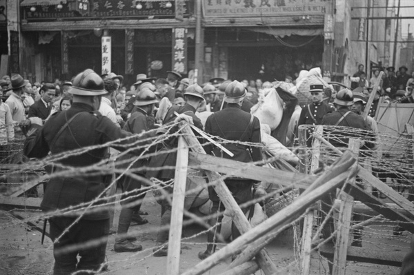 French soldiers checking baggage, by barricade, Shanghai