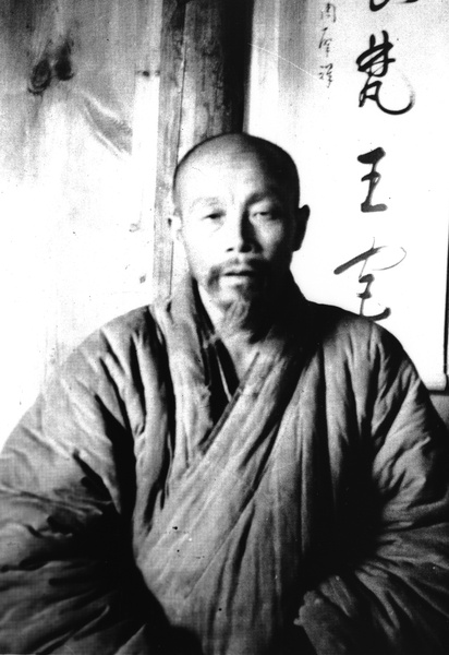 Buddhist monk, with scroll in background, near Hangzhou