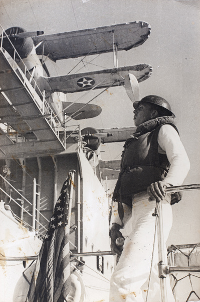 American sailor on 'AUG 3' tender, beside USS Augusta, Shanghai