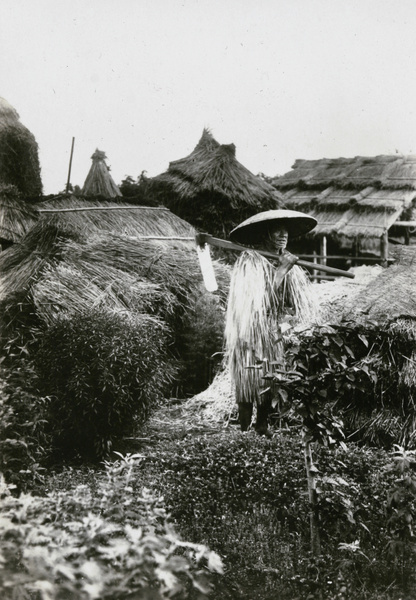 Man wearing straw raincoat