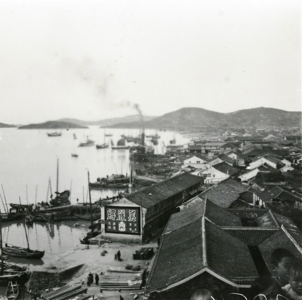 A small steamer and other boats at a seaside harbour, Hong Kong