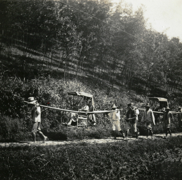 Two sedan chairs and bearers