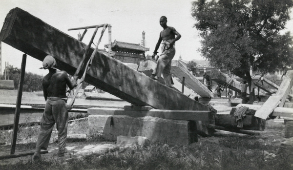 Sawing beams in a lumber yard, Peking