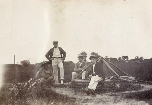 Four men by a water irrigation pump