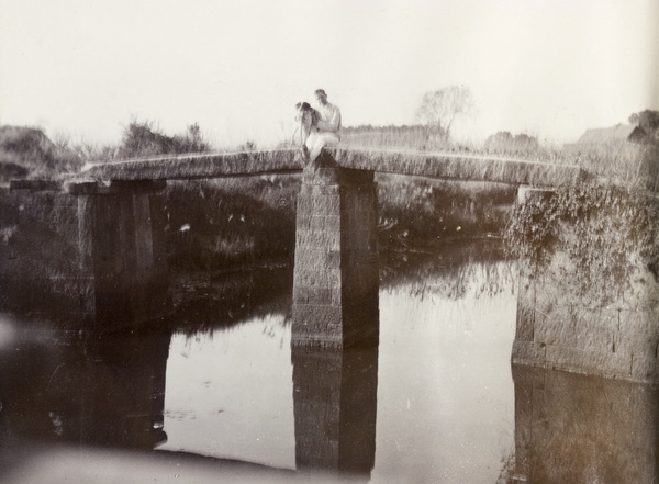 Man and dog on stone bridge