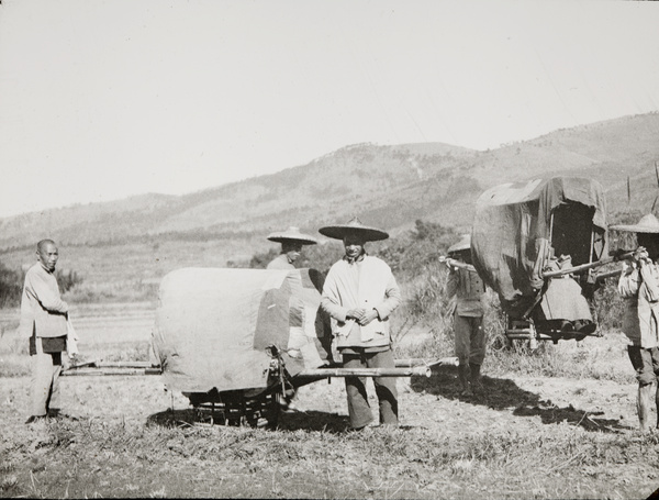 Two sedan chairs and bearers, in a field