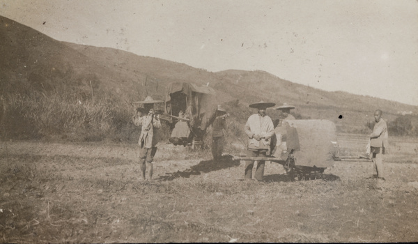 Two sedan chairs and bearers, in a field