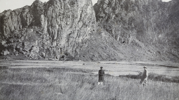 Two people standing in a field near Chunwan (春灣) Stone Forest, Yangchun (阳春市), Guangdong province