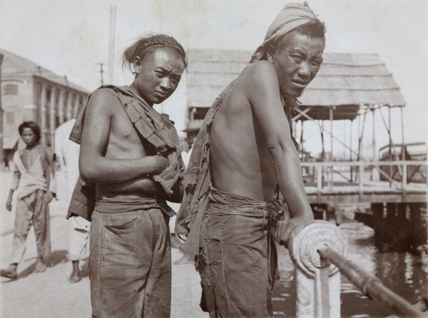 Two workers by a pier