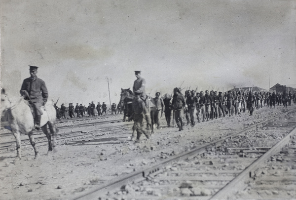 Revolutionary troops marching beside railway tracks