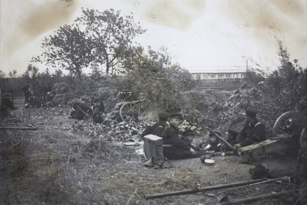 Revolutionary soldiers eating and smoking beside field guns