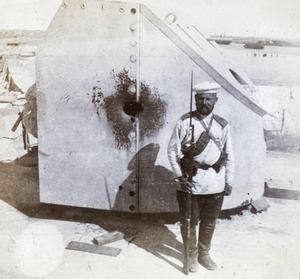 Foreign soldier beside a damaged gun