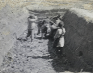 People in a pit, with something