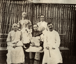 Group of foreigners by bamboo fence