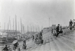 Porters carrying pails up steps, Changsha