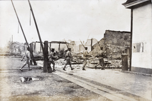 Chinese soldiers beside a level crossing and among ruins, Hankow