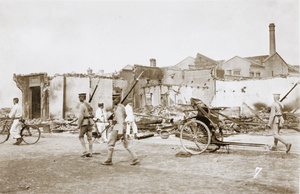 Chinese soldiers walking past ruined buildings, Hankow