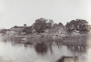 A grave mound with an inscribed tablet beside a bridge