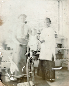 Baby Jim on a bicycle, with sister and amah