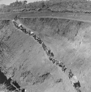 A porter train crossing a gully