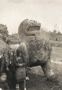 Winged lion (Pixiu), with a farm worker and a child, tomb of Hsiao Hsui, near Nanking