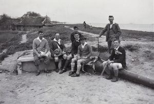 Group of hikers resting on a damaged artillery piece beside the Huangpu River, near Shanghai