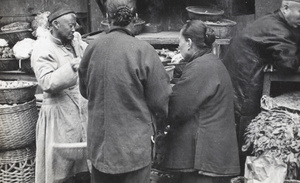 Women buying produce from a street market trader