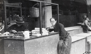 A man counting coins and another man smoking