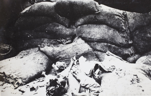 A dead body beside sandbags