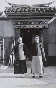 A woman with bound feet and a man standing in front of a decorated doorway