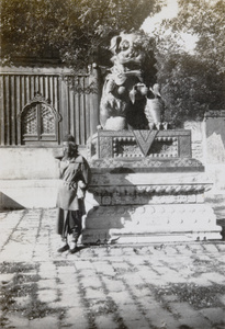 A beggar beside the male bronze lion (tongshi 銅獅), Yonghe Temple (雍和宮) ‘The Lama Temple’, Beijing