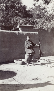 A woman with bound feet, with baskets and materials for winnowing grain